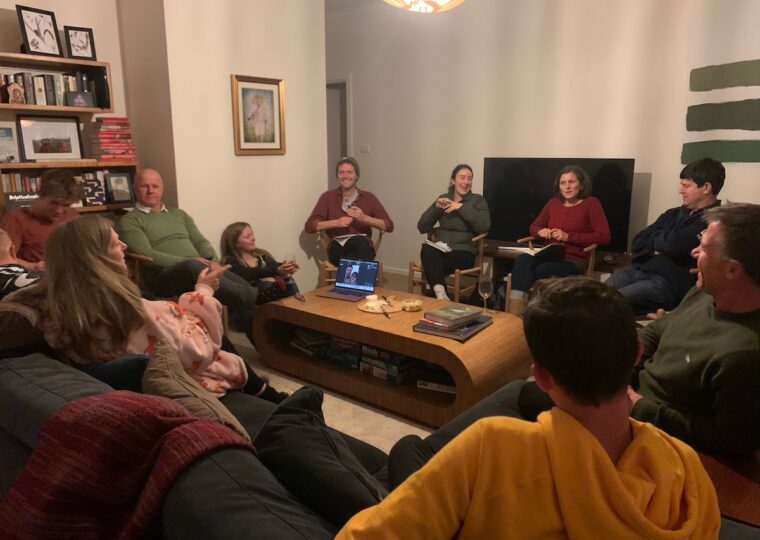 A group of people gathered in a circle in a living room