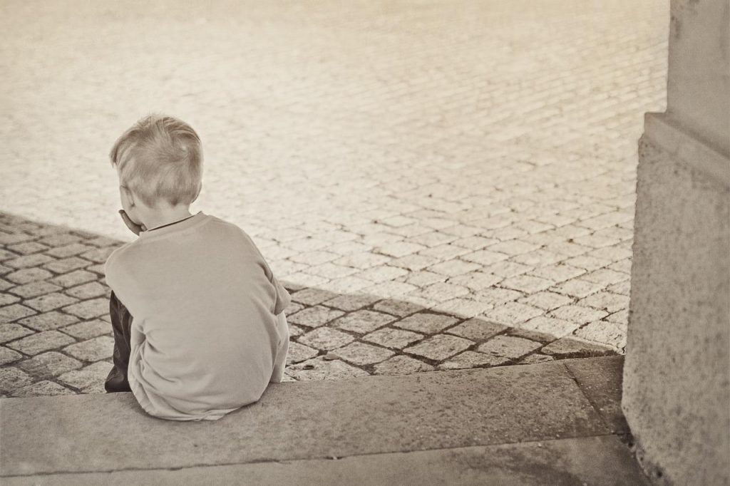 A child sits alone as if in time out